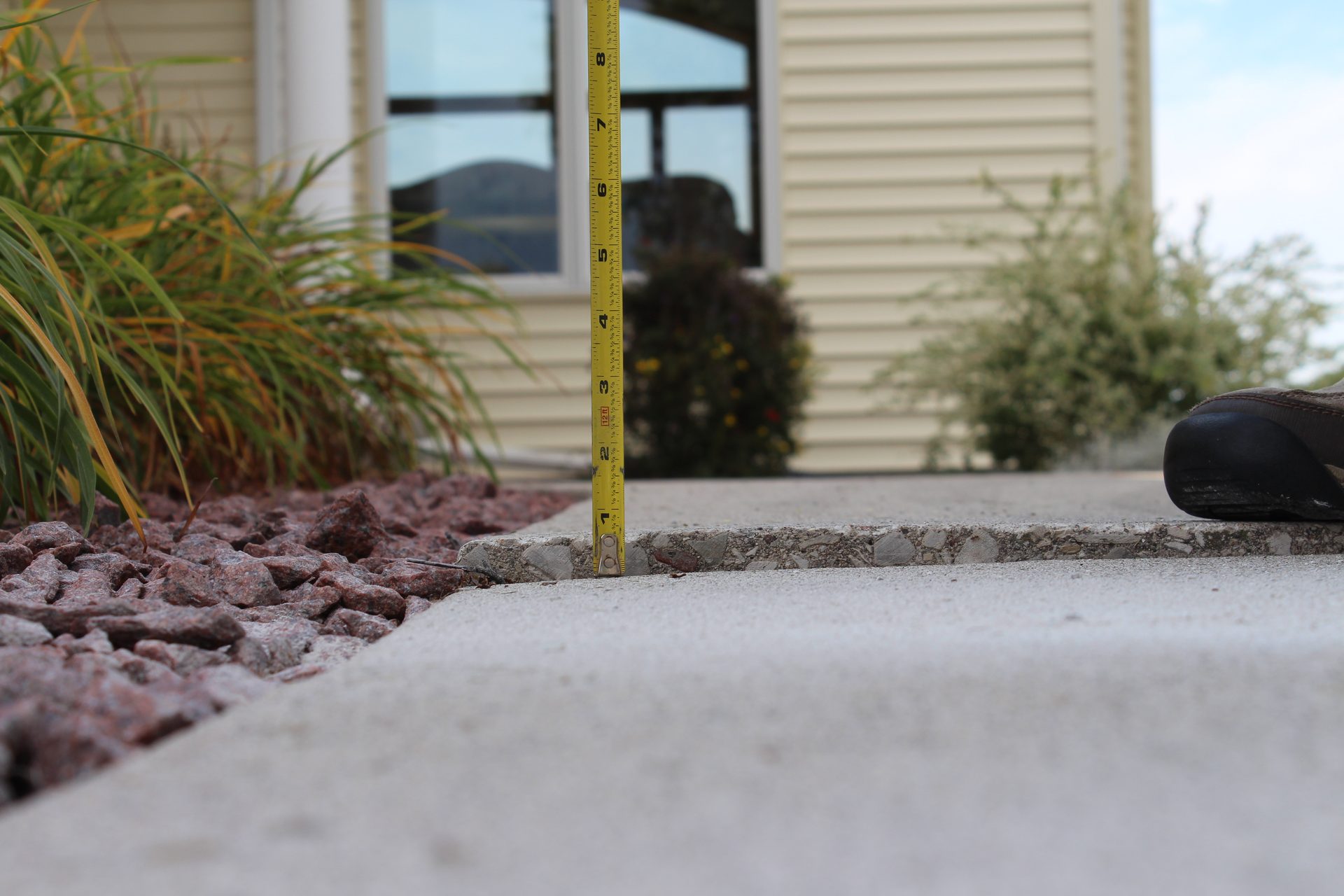 Settled walkway slab with raised edge before concrete lifting repair
